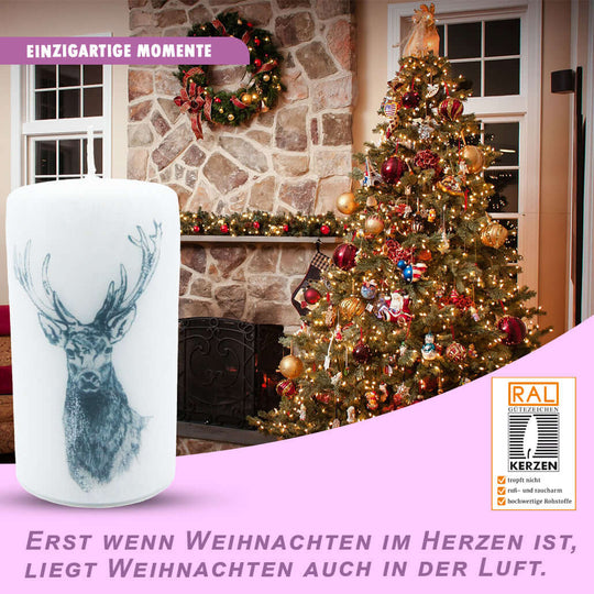 Weihnachtskerze für Adventskranz 13x7cm mit Hirschmotiv vor festlich dekoriertem Weihnachtsbaum